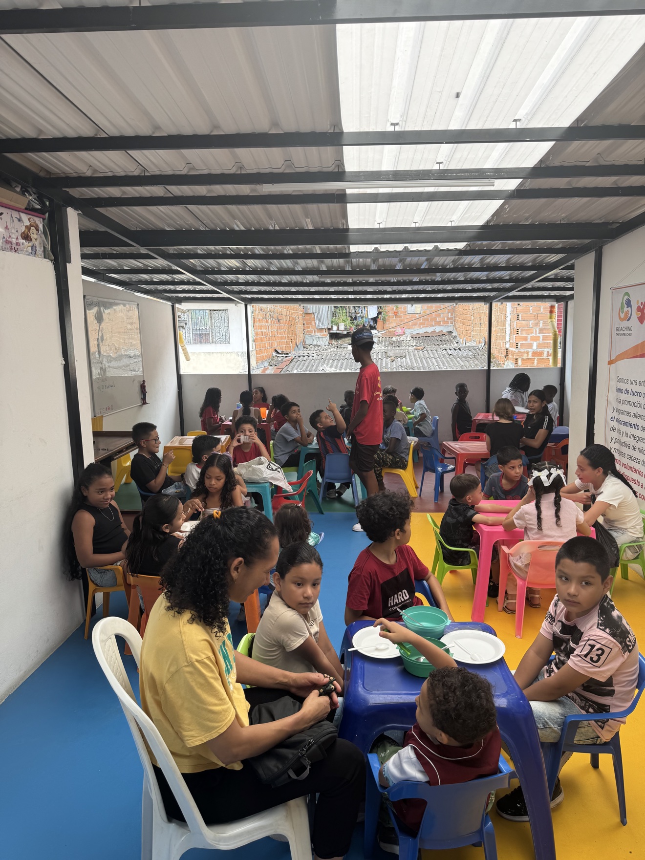 Children sharing a meal at colorful plastic tables