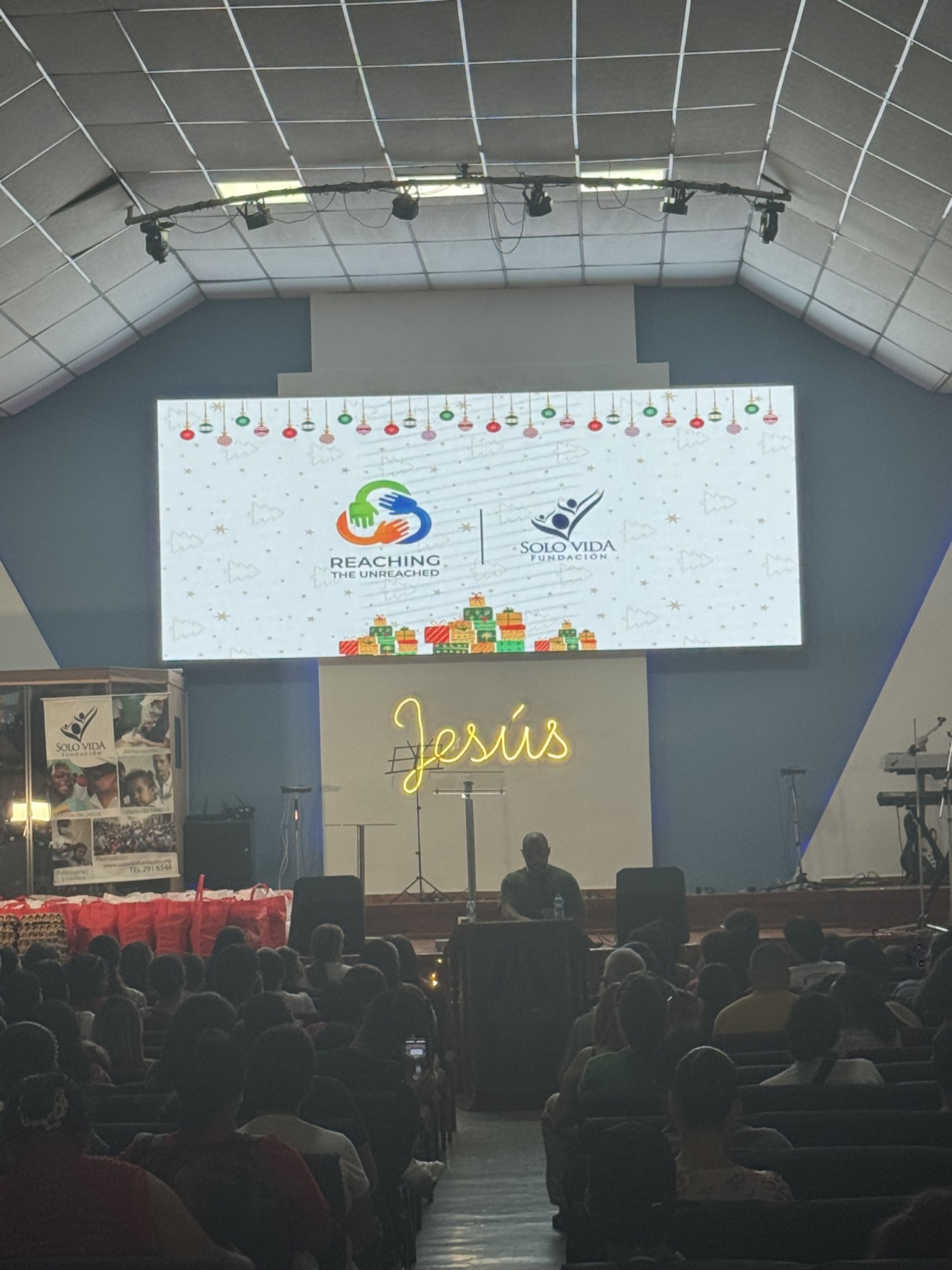 Church auditorium with RTU and Fundación Solo Vida logos on the big screen