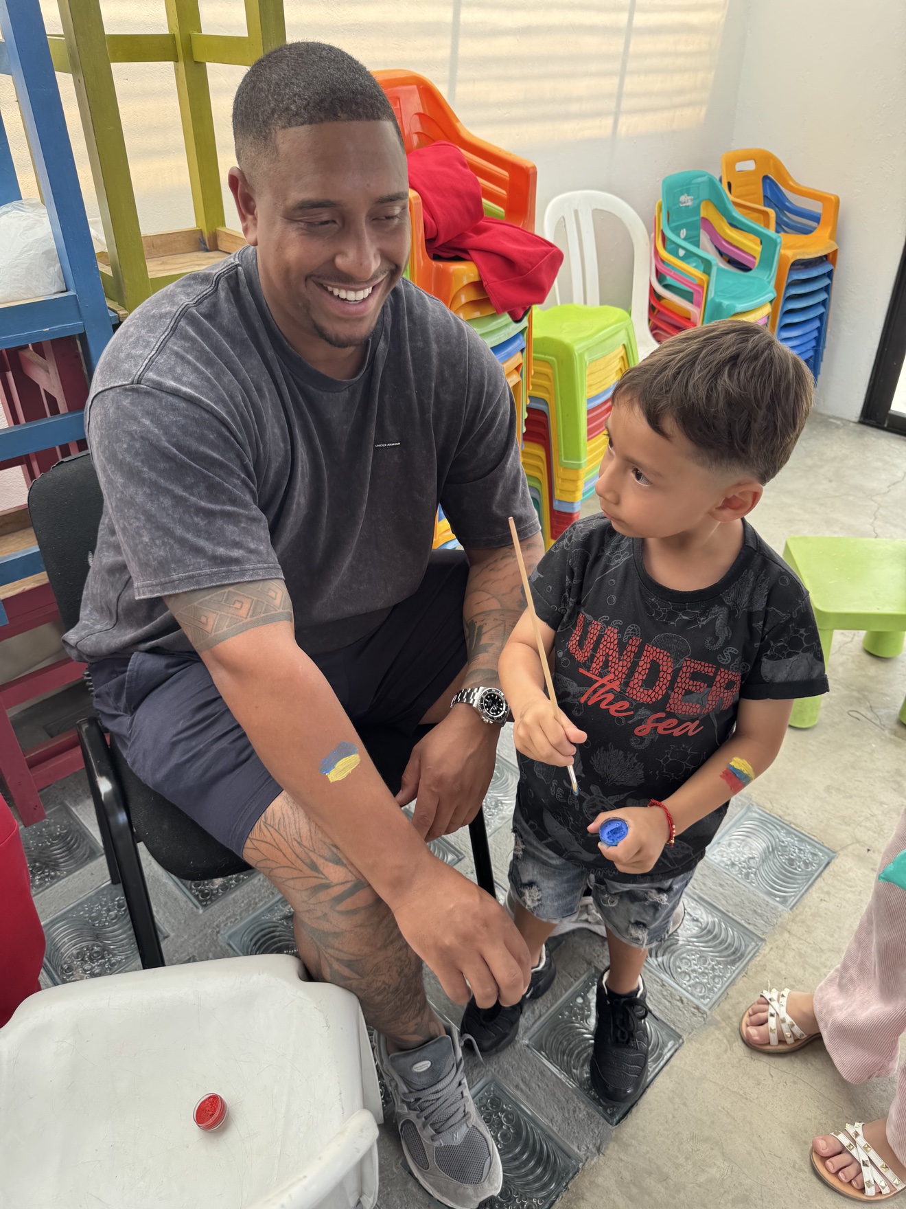 Volunteer doing face paint with a young boy