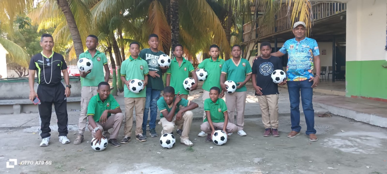 Youth soccer team group photo, kids in green jerseys holding soccer balls