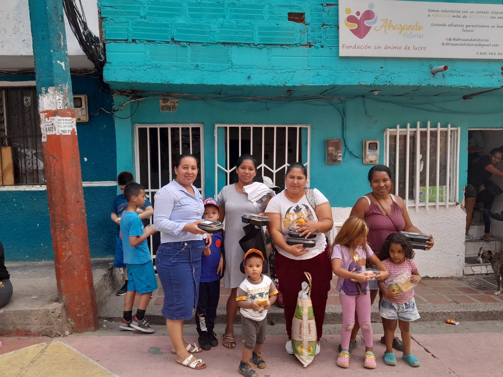 Families receive meals outside Fundación Abrazando Historias in Medellín.