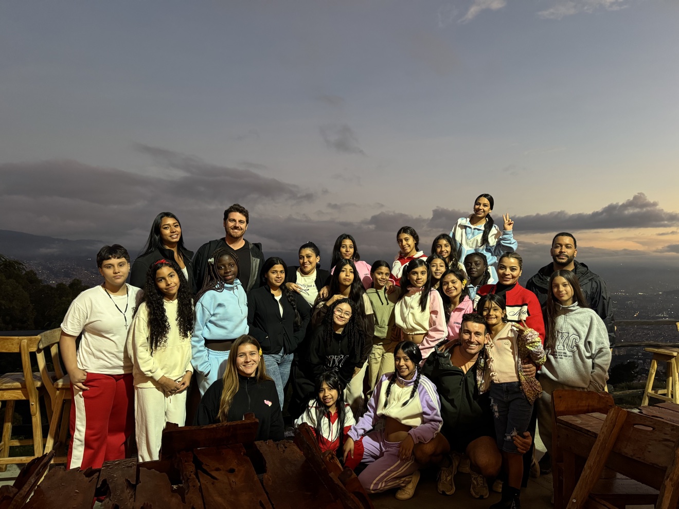 Youth group photo at sunset with city view in Medellín