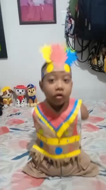 A boy in a paper headdress at a cultural activity.