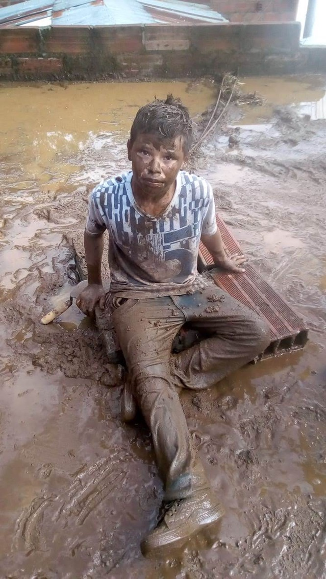A boy in the mud after the flooding.