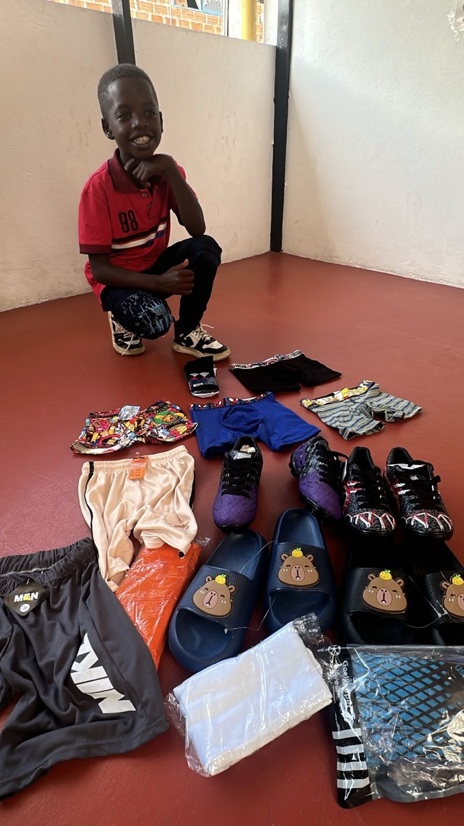 A boy with donated clothes and supplies.