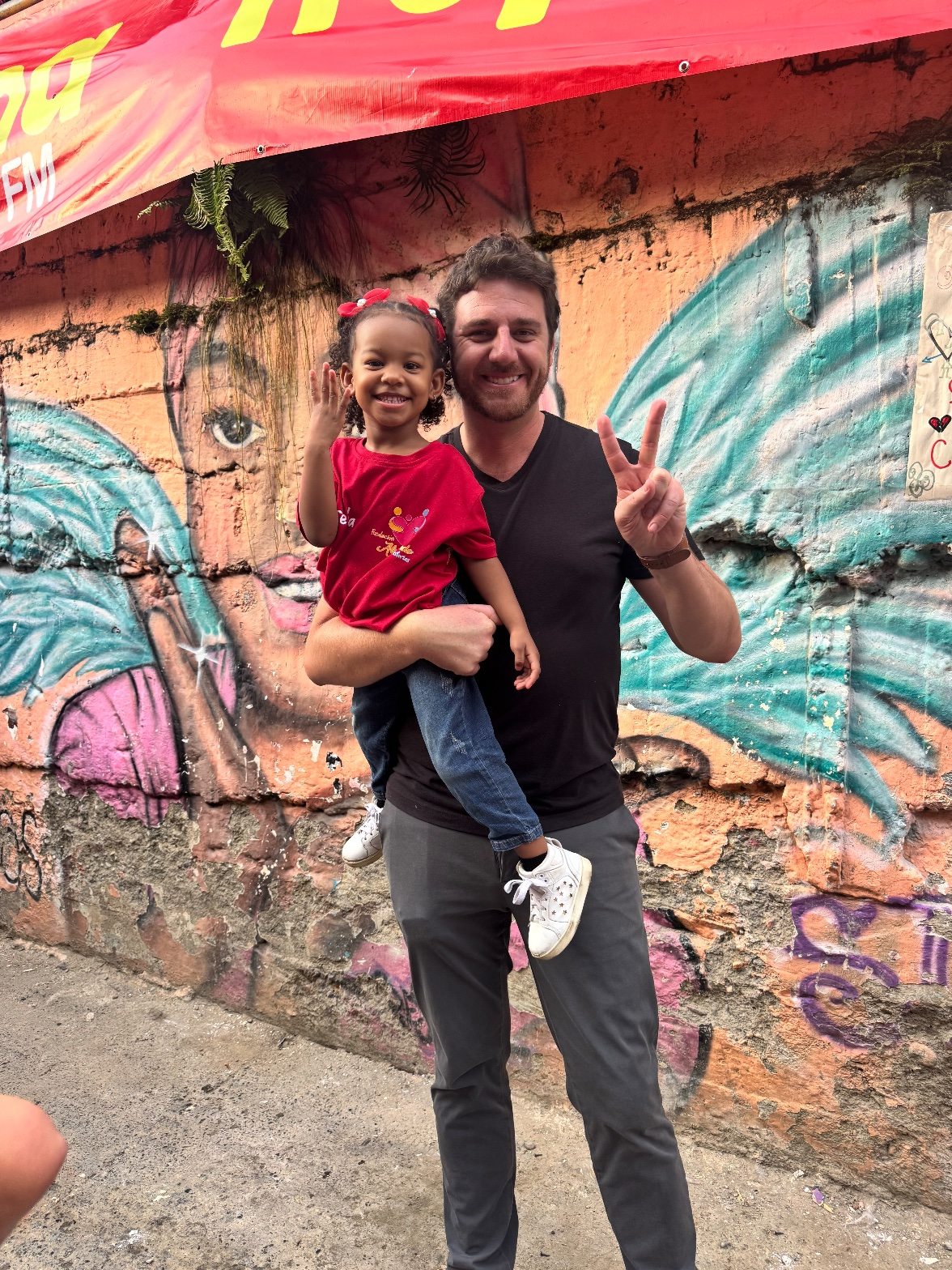 A man sitting on a colorful floor sharing a moment with a young boy