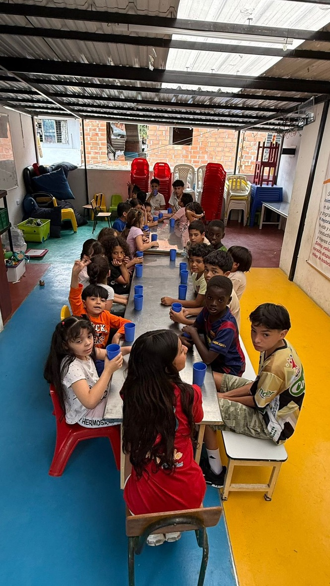Children at the table with their cups.