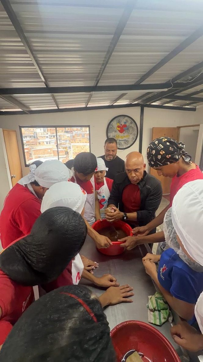 Coach Chonto joins the baking class at Fundación Abrazando Historias, Medellín, October 2026.