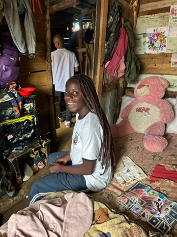 A girl at home with her belongings.