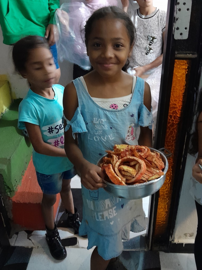 A proud helper carries food to share.