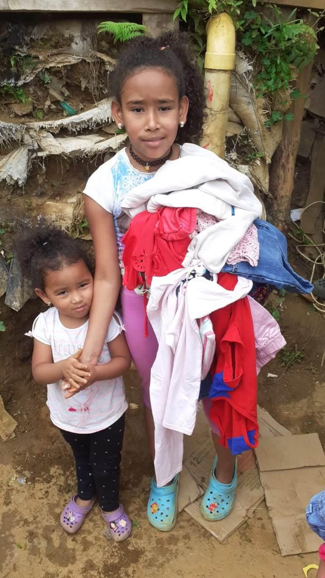 Girls with an armful of donated clothes.