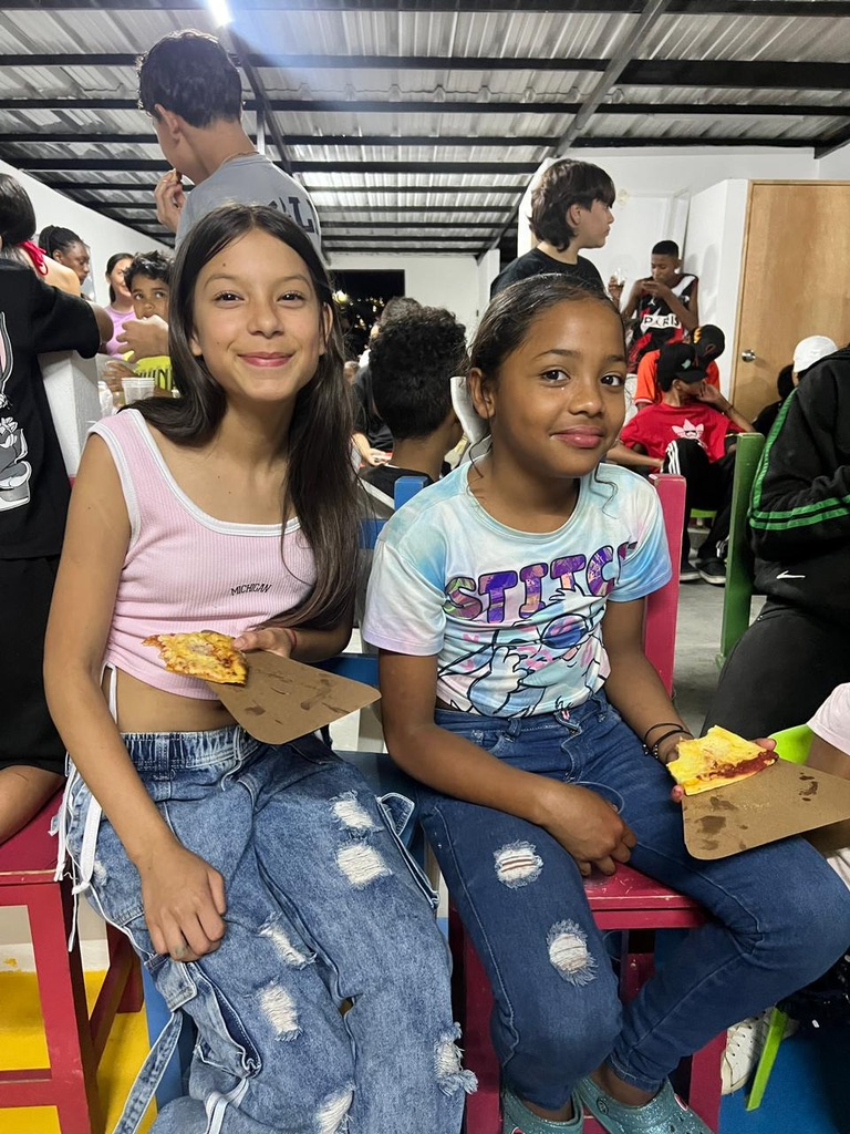 Girls share pizza at the community center.