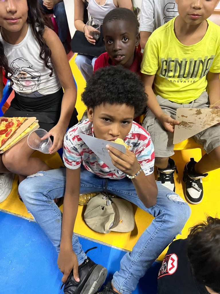 Kids eating together on the floor mats.