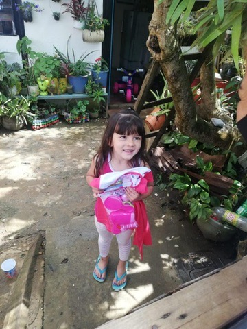 A little girl carries her new things home.