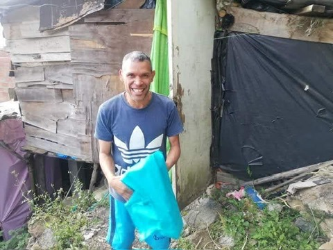 A neighbor receives a bag of donated clothing.
