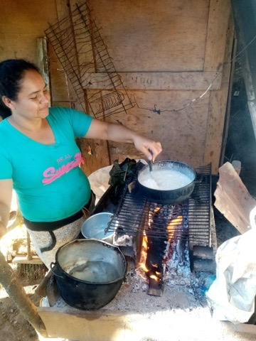 A mother cooks for her family over a wood fire.