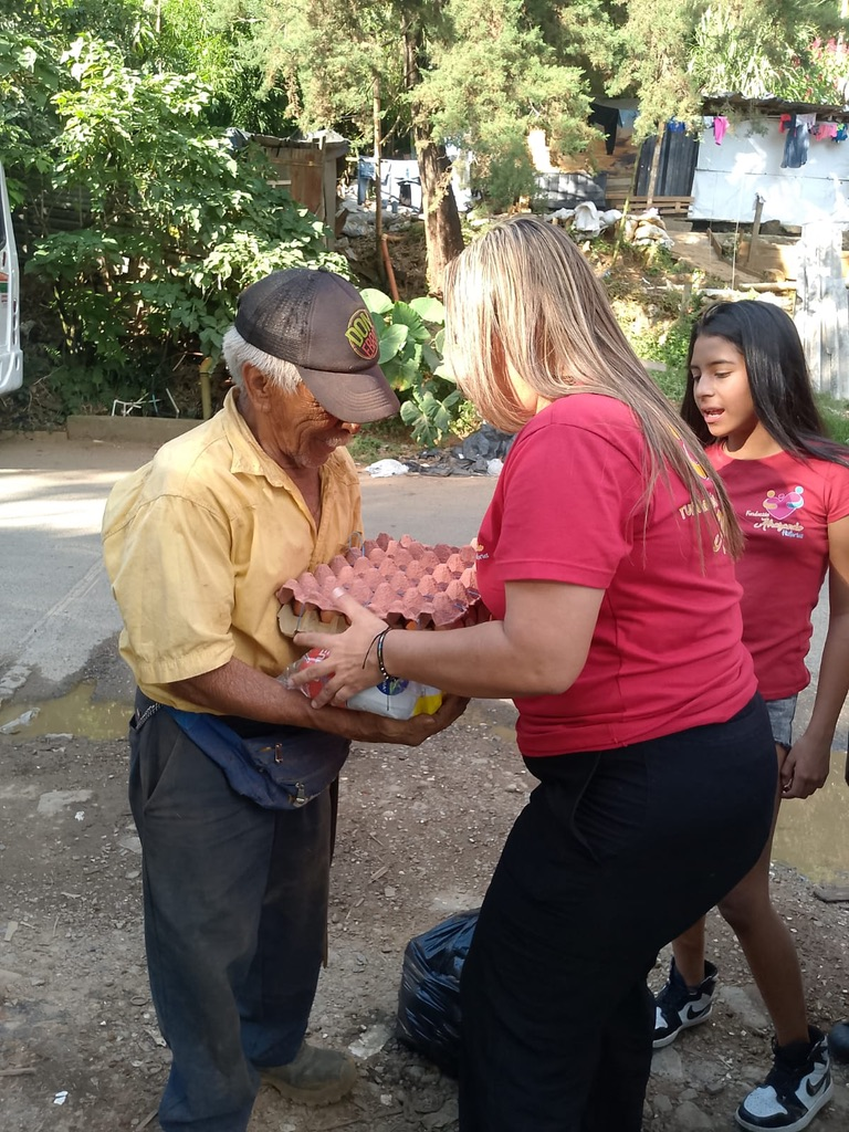 A volunteer hands a carton of eggs to a neighbor.