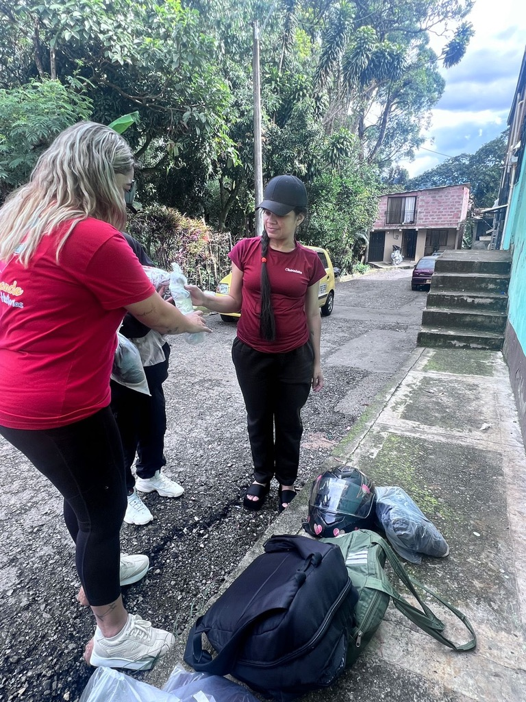 A volunteer hands out donated clothing.