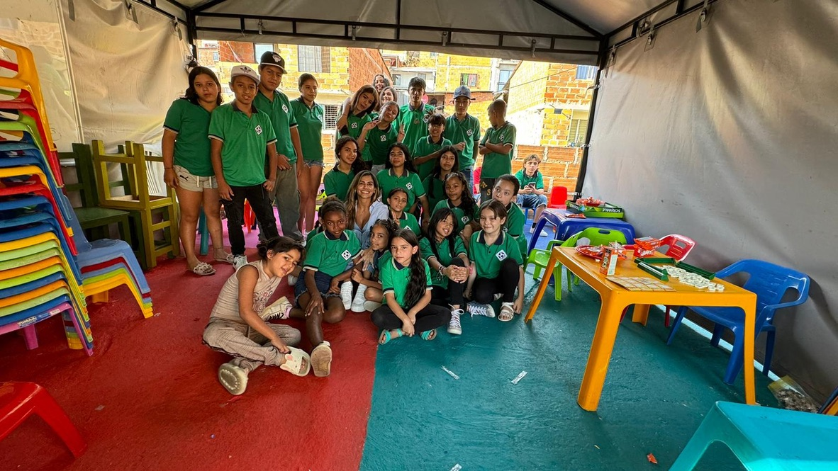 Volunteers and children together under the tent.